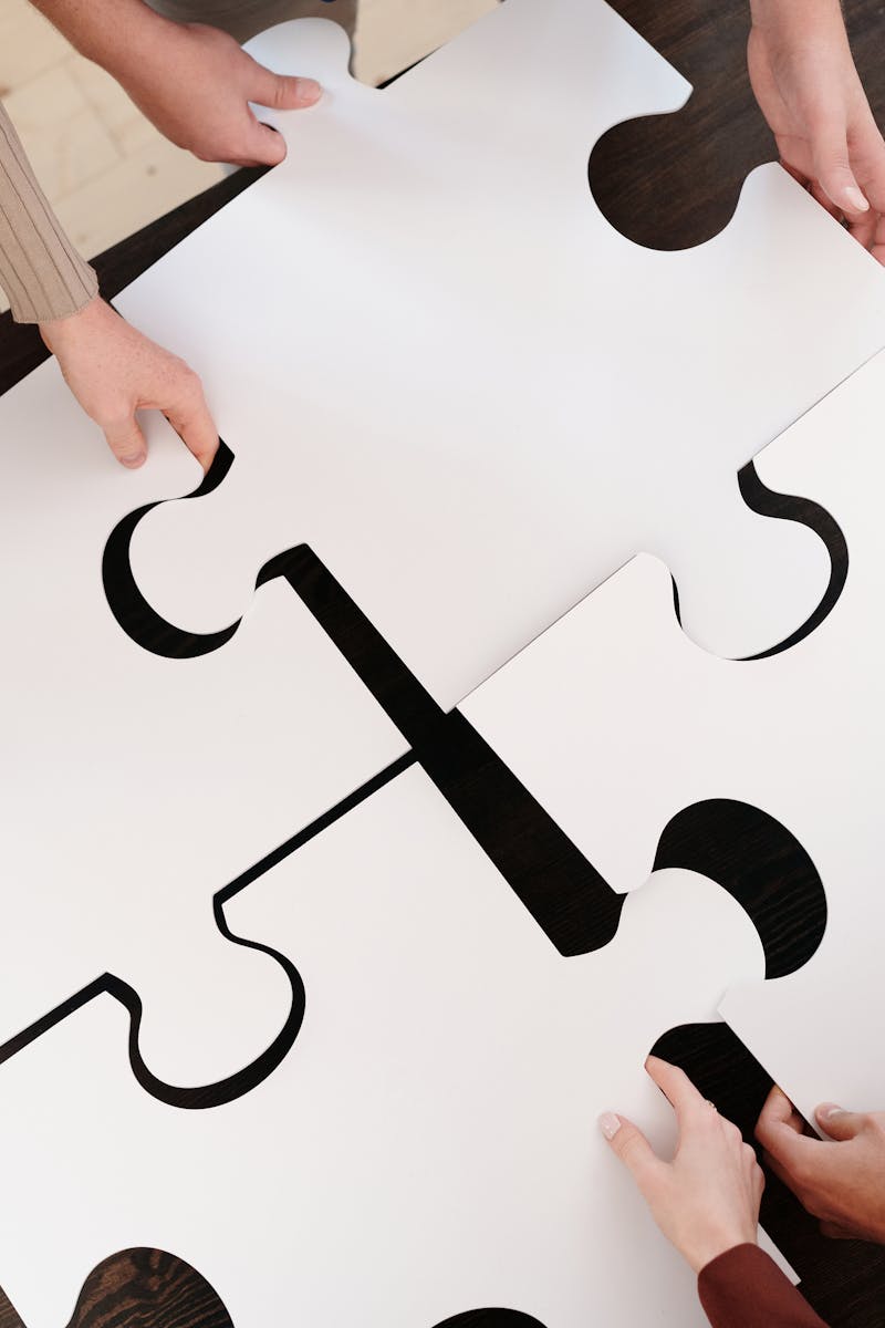 Group collaborating on assembling large puzzle pieces symbolizing teamwork and unity.